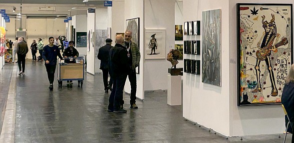 Larger image in new window. Discovery Art Fair, October 31st, 2024. Painting at right 'Buy Art Save a Crazy Person' by Erich Schobesberger